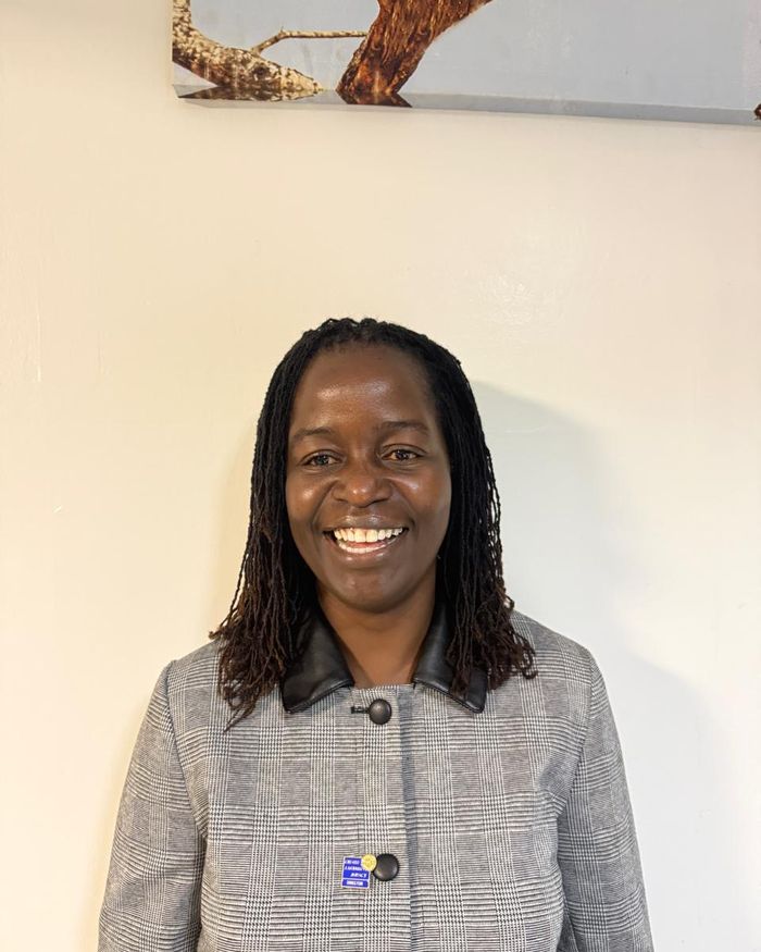 Membership Director PP Isabella Olwenyo, smiling, wearing her Rotary pin