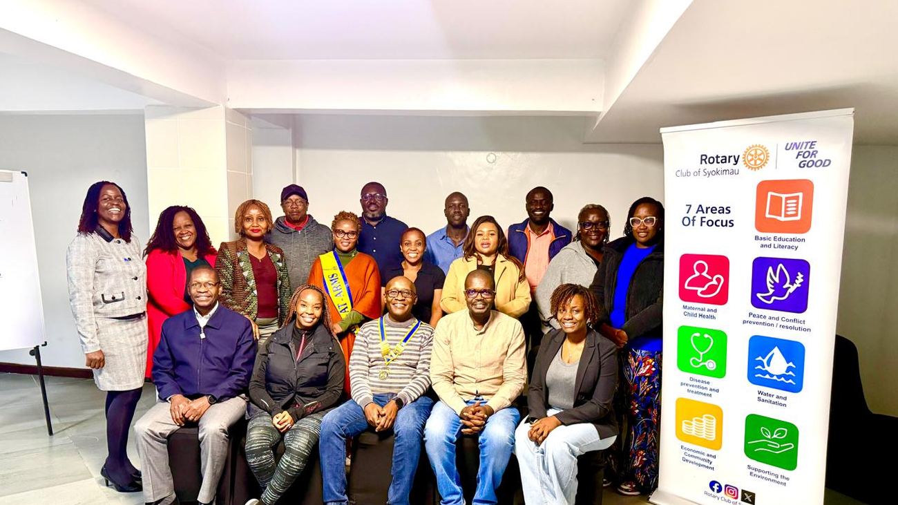 Members of the Rotary Club of Syokimau gathered for a full club photograph beside the Areas of Focus banner