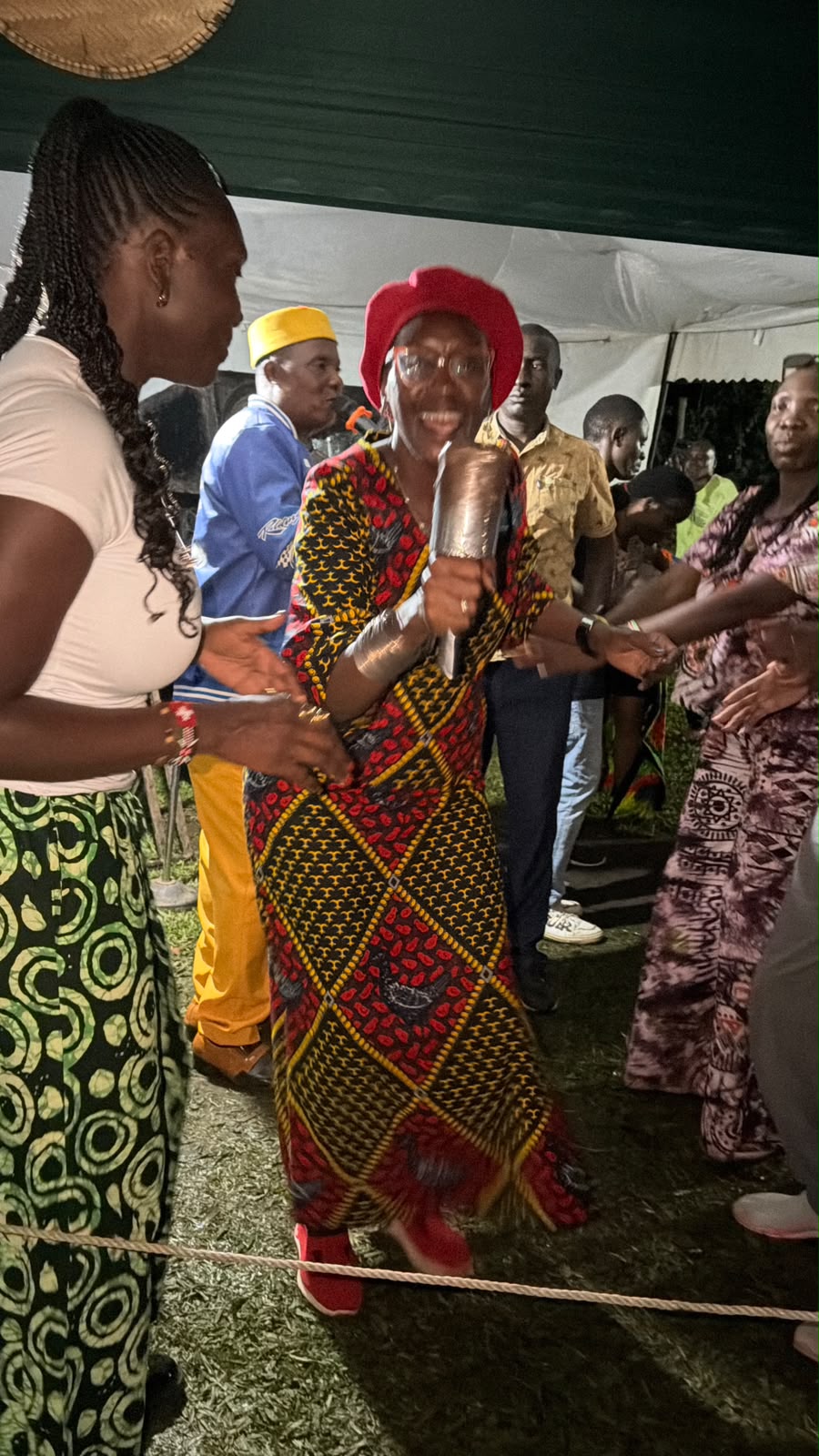 Rtn. Prof. Margaret Awuor Owuor dancing in celebration, surrounded by family and friends under a tent in Siaya