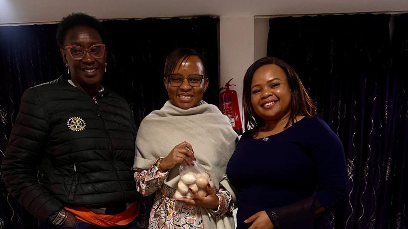 Assistant Governor Sylvia Njambi standing with two members after her visit to the club